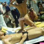 Cannes Film Festival semi nude woman posing topless on beach with boyfriend. Amateur and Press photographers at work working. 1980s France 1980 Stock Photo