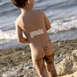 Young boy naked nude or bare with sandy legs from behind looking at the sea in Cyprus Stock Photo