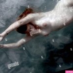 Naked pregnant woman swimming underwater Stock Photo