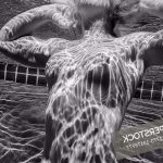 Woman swimming naked underwater
