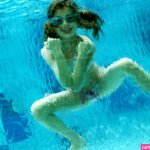 Girl swimming underwater in swimming pool
